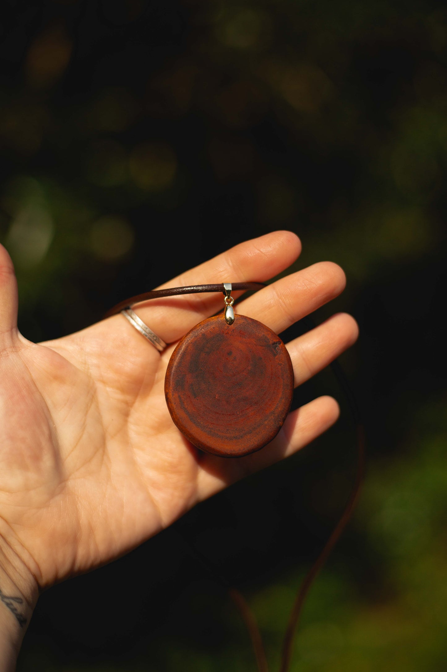 Hand-carved eucalyptus slice pendant on gold-plated bail
