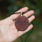 Hand-carved eucalyptus slice pendant on gold-plated bail