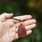 Hand-carved eucalyptus tear drop slice pendant on gold-plated bail