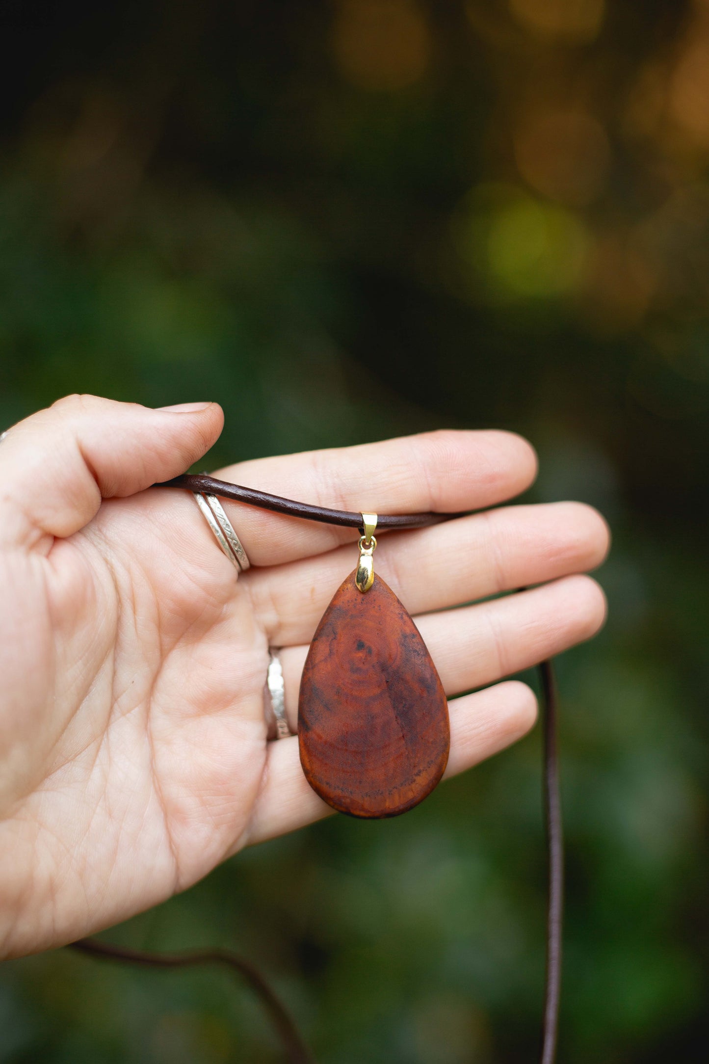 Hand-carved eucalyptus tear drop slice pendant on gold-plated bail