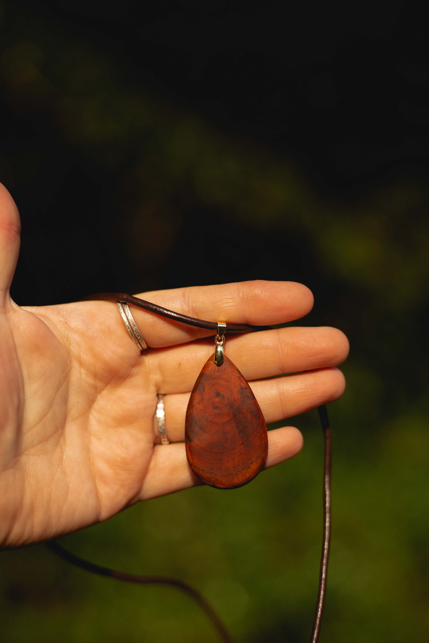Hand-carved eucalyptus tear drop slice pendant on gold-plated bail